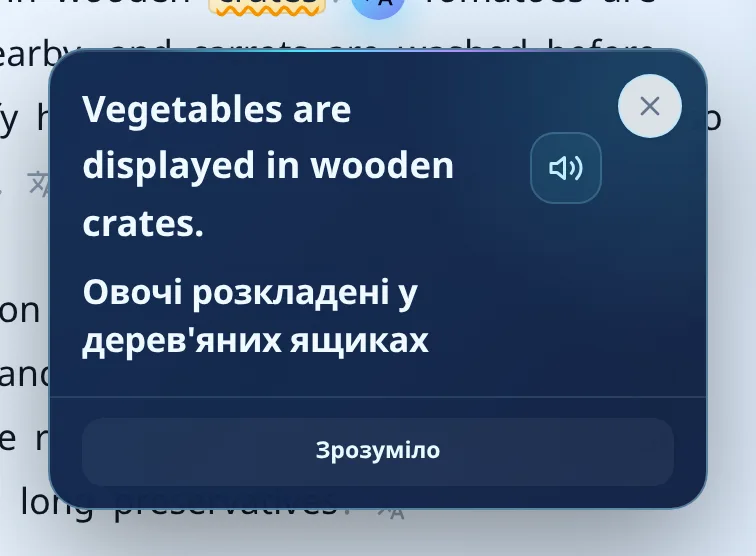 Спливне вікно з англійським реченням «Vegetables are displayed in wooden crates», українським перекладом «Овочі розкладені у дерев'яних ящиках», кнопкою озвучення та кнопкою «Зрозуміло»